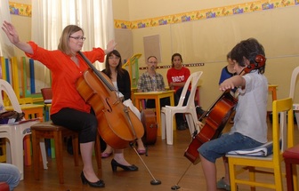 Teacher models to student how to hold instrument